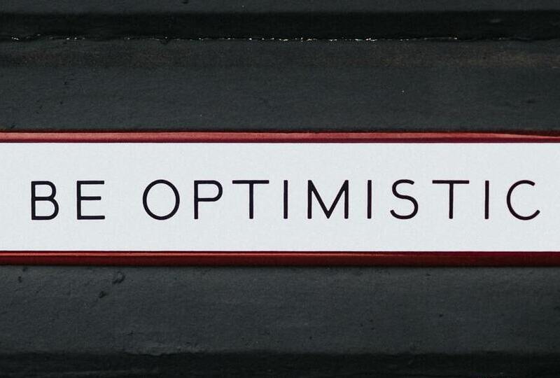 A sign that says Be Optimistic